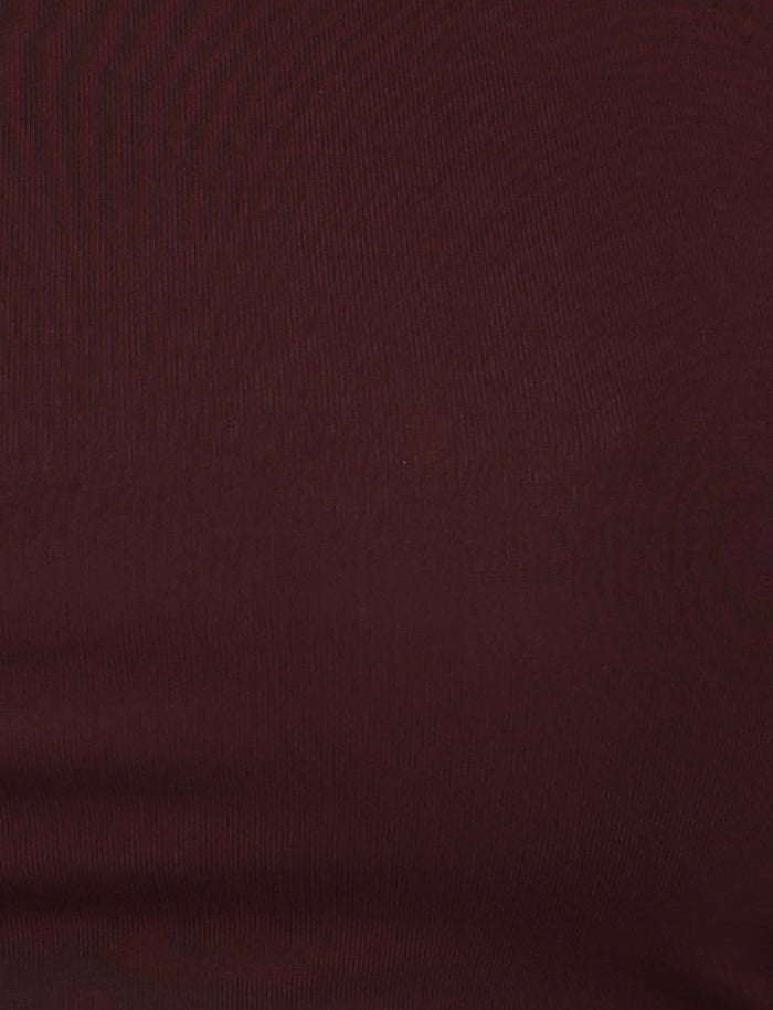 Close-up view of someone wearing a fitted, dark reddish-brown fabric in a chocolate colourway. The material appears smooth with a slight sheen, revealing subtle horizontal texture lines typical of knitted or stretch fabric, suggesting it could be the BIANKA TOP - BROWN : CHOCOLATE by TIGERMIST with its bodycon silhouette.
