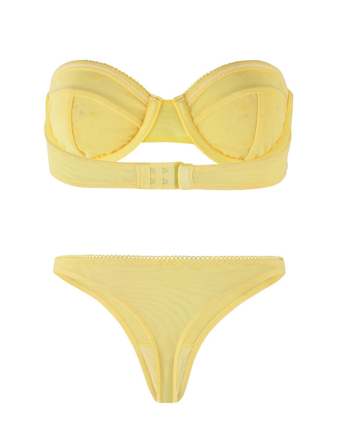 The TIGERMIST BIM LACE SET in yellow includes a bandeau-style bra with structured cups and a rear clasp closure, paired perfectly with matching low-rise thong panties. Made from a combination of mesh and lace, this set boasts a sheer and delicate appearance accented by subtle decorative stitching along the edges.