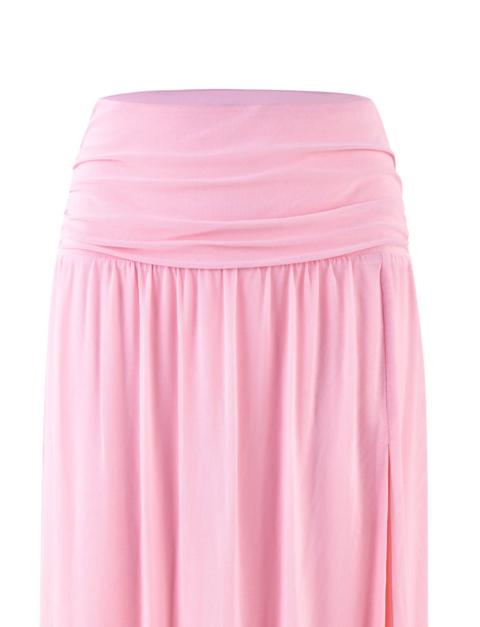 A close-up view of the TIGERMIST BIRDEE SKIRT - PINK : BABY PINK. The long, flowing skirt features a ruched waistband and soft, draping fabric. The lightweight material gives it a delicate and elegant look. The background is plain and white.