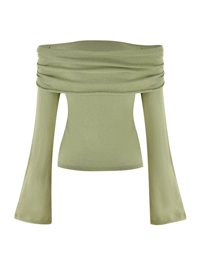 The DIEDRE JUMPER - GREEN by TIGERMIST is an off-the-shoulder, light green long-sleeve top featuring a wide, draped neckline and flared sleeves. Made from high stretch fabric, it feels soft and slightly textured.