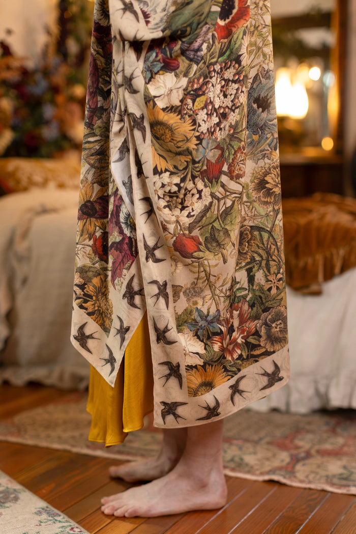 Model wearing a soft bamboo-viscose flowy duster featuring rich 1700s botanical blooms and swallow trim - Market of Stars