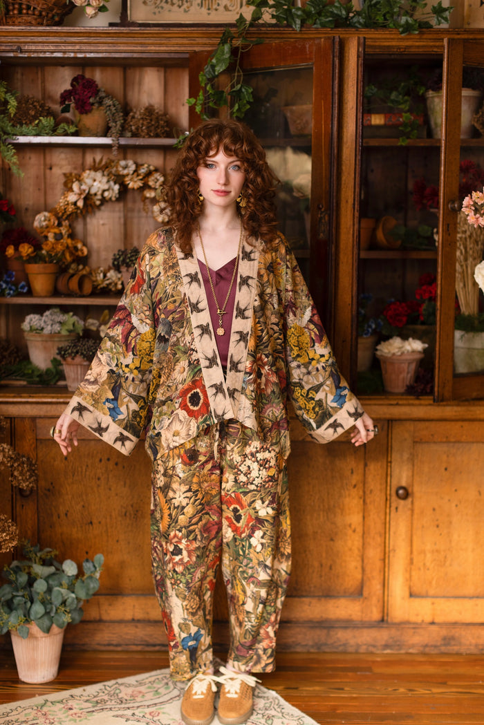 Model wearing a soft bamboo-viscose cropped duster featuring rich 1700s botanical blooms and swallow trim - Market of Stars