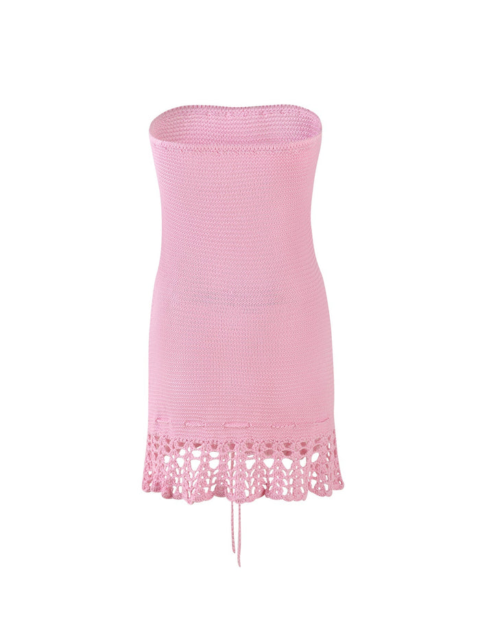 Image of the TIGERMIST JULANE DRESS - PINK featuring a fitted design with a slightly flared bottom. The hemline is adorned with a delicate crochet pattern that includes small cutouts, adding a touch of texture and elegance to the piece.