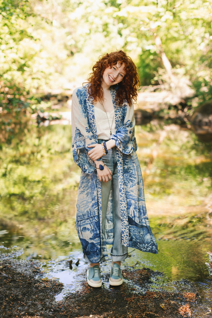 Model wearing Let the Light In long opera duster kimono featuring print of Delft blue and white landscape pottery, and positive message of light and hope - Market of Stars