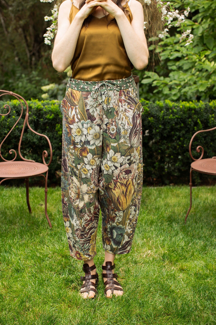 Model styled in Love Grows Wild Artist Pants featuring 1700s hand-coloured floral etchings and bumblebee trim – relaxed lantern hem and cropped fit – Market of Stars