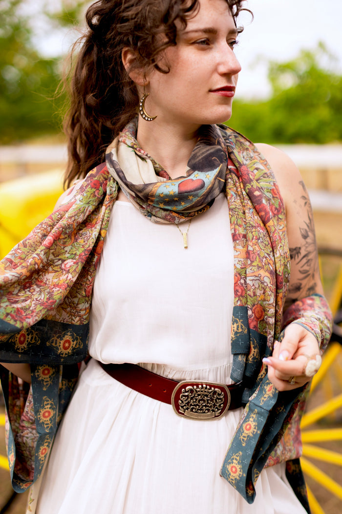 Model wearing a bamboo-viscose scarf ft. a woman astride a rearing horse, soft vintage florals, rosettes and lithographs from the 1800's - Market of Stars