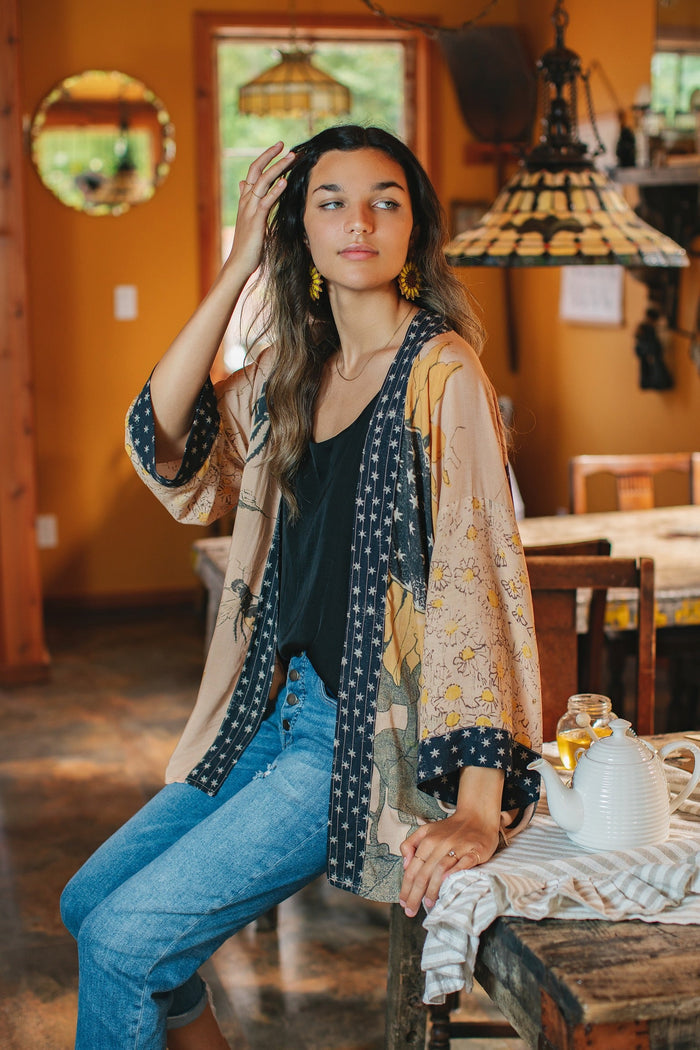 Model wearing our matinee length kimono featuring vintage-inspired Milk & Honey print with 1904 typography and floral woodcuts – Market of Stars