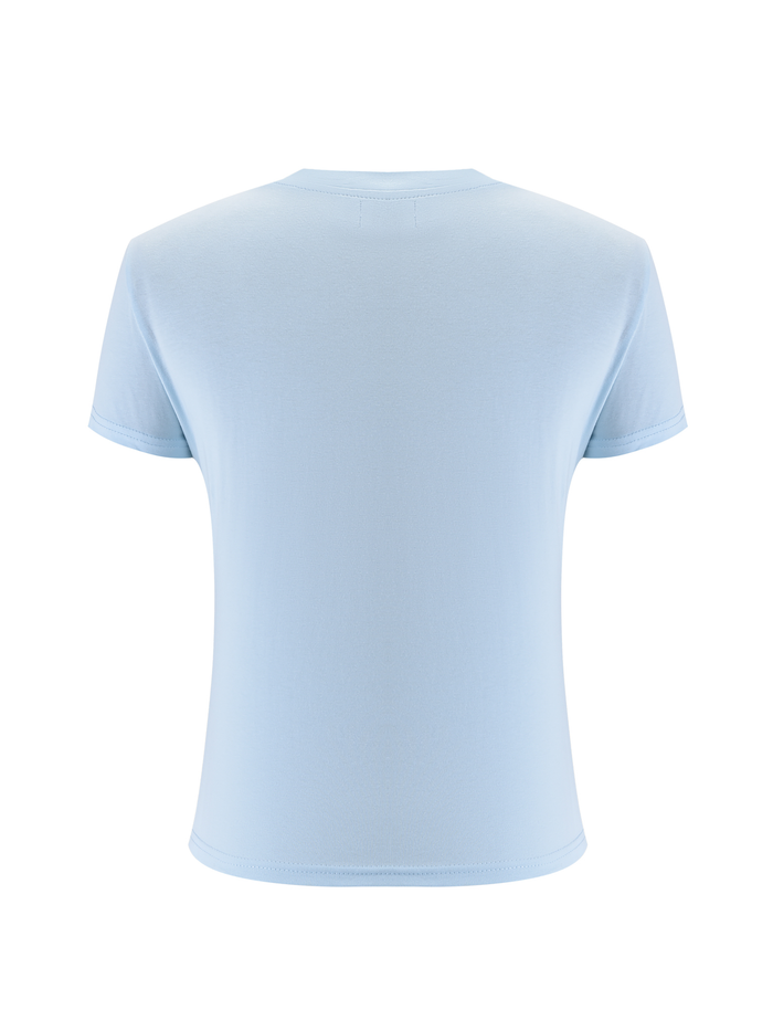 The SAPHIRA TEE - BLUE by TIGERMIST is a light blue, short-sleeve top shown from the back against a white background, featuring subtle blue rhinestones for a hint of sparkle in this classic design.