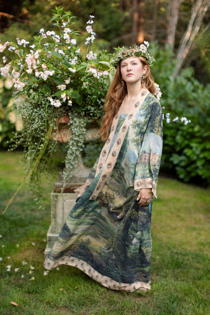 Model wearing a maxi-length slip dress ft. vintage artwork & unicorn lorn set against a mossy-green landscape — a romantic piece for the modern dreamer - Market of Stars
