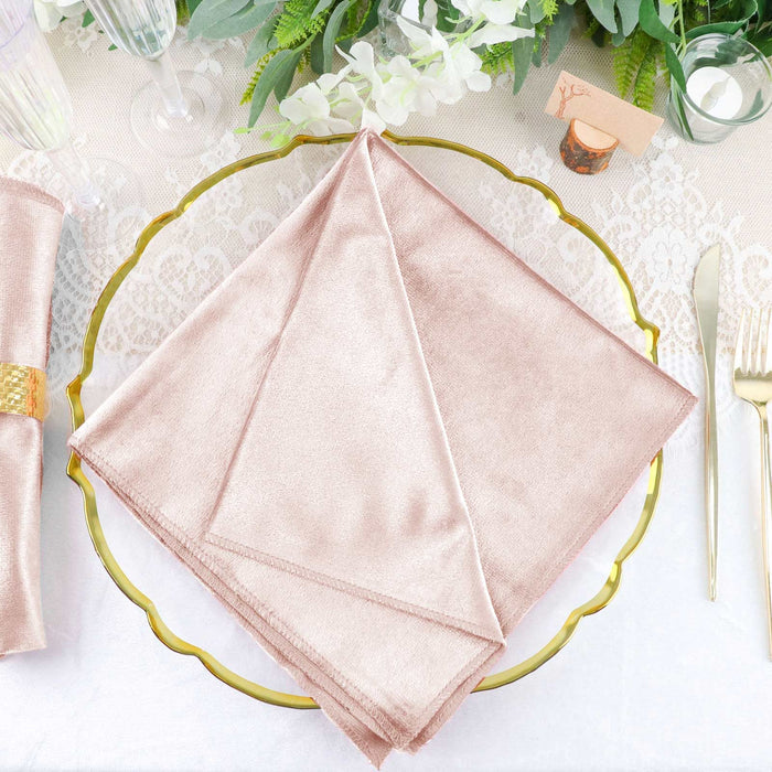 Rose gold napkin elegantly folded on a decorative plate at a dining table.