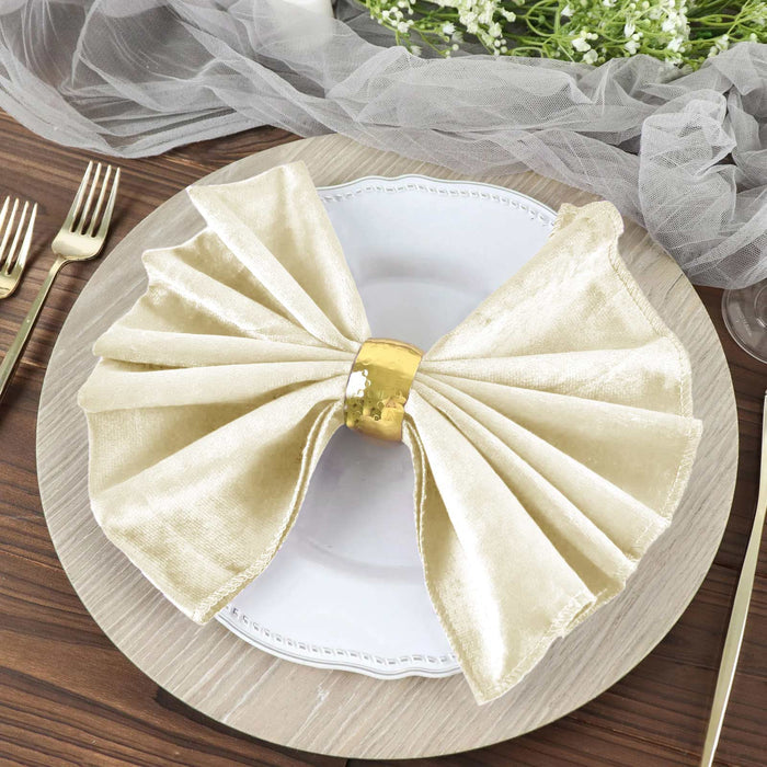 Elegant gold napkin bow on a white plate, styled on a wooden table.