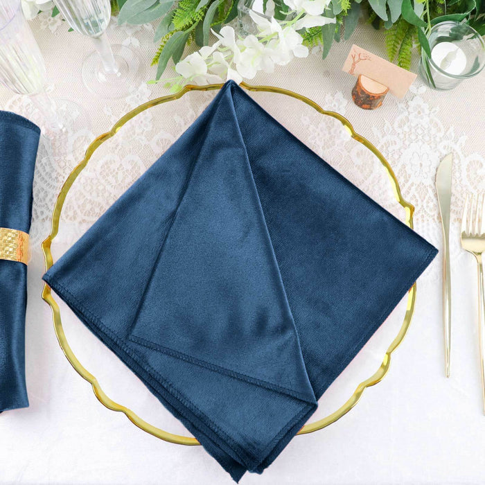 Navy blue satin napkin on a decorative gold plate.