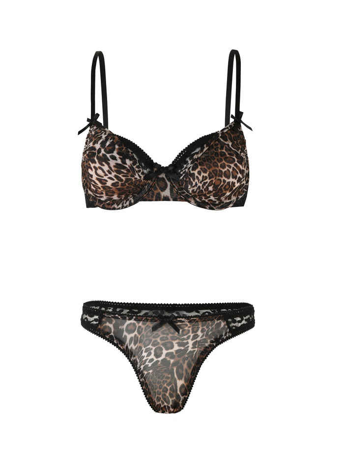 The ALANIS SET - NEUTRAL : LEOPARD by TIGERMIST is a leopard print lingerie set that includes a leopard print bra and matching g-string. The bra features thin black straps adorned with small black bows at the base of each strap, while the panties are designed with black trim and a small bow at the center front.
