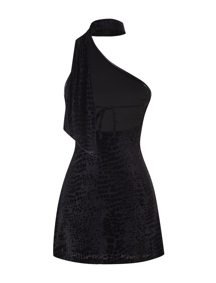 The Tigermist Allira Burnout Mini Dress 2.0 in black is a chic one-shoulder dress showcasing a sophisticated snake pattern crafted from luxurious velvet burnout fabric. It features an asymmetrical neckline with a tie detail and offers a fitted silhouette, ideal for making a subtle yet striking impression.
