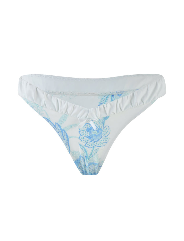 Introducing the AMARAN BIKINI BOTTOM - BLUE : FLORAL TAPESTRY by TIGERMIST: a white cheeky bikini brief featuring a subtle floral tapestry pattern in light blue. The fabric offers a smooth texture with a minimalist design, complemented by delicate floral elements.