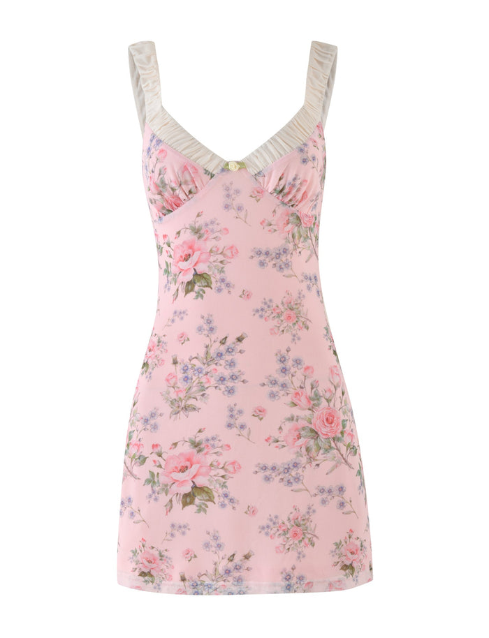 The AMARAN MINI DRESS - PINK : FLORAL : WILD FLOWER by TIGERMIST is a sleeveless pink floral print dress, displaying beautiful roses and small blue flowers. It includes a bustier-style gathered bust with a delicate decorative button and delightful white ruffled straps.
