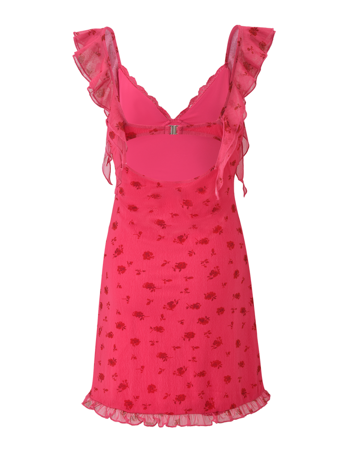 The TIGERMIST AMARIS MINI DRESS - DITSY FLORAL is a bright pink V-neck mini with ruffled straps, cut-out back, and a mesh overlay in a subtle floral print. Its fitted bodice and ruffled hem give it a playful, flared silhouette.