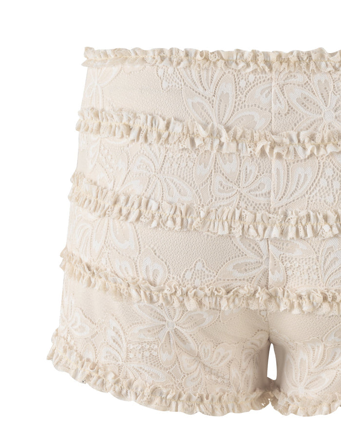 Introducing the ANELISA SHORT from TIGERMIST: a pair of white, lace-trimmed mini shorts that feature multiple horizontal rows of ruffles. The delicate and elegant floral-patterned fabric offers a snug fit and is designed to sit at mid-rise waist.
