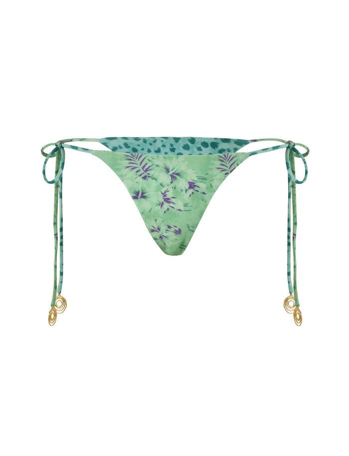 The AUTUMN BIKINI BOTTOM - GREEN : FLORAL : ANIMAL by TIGERMIST features a green triangle bikini bottom adorned with a tropical leaf pattern and touches of purple. It boasts adjustable side-tie strings decorated with gold-tone spiral metal accents at the ends. The fabric has a slight sheen, adding to its vibrant and summery appearance.