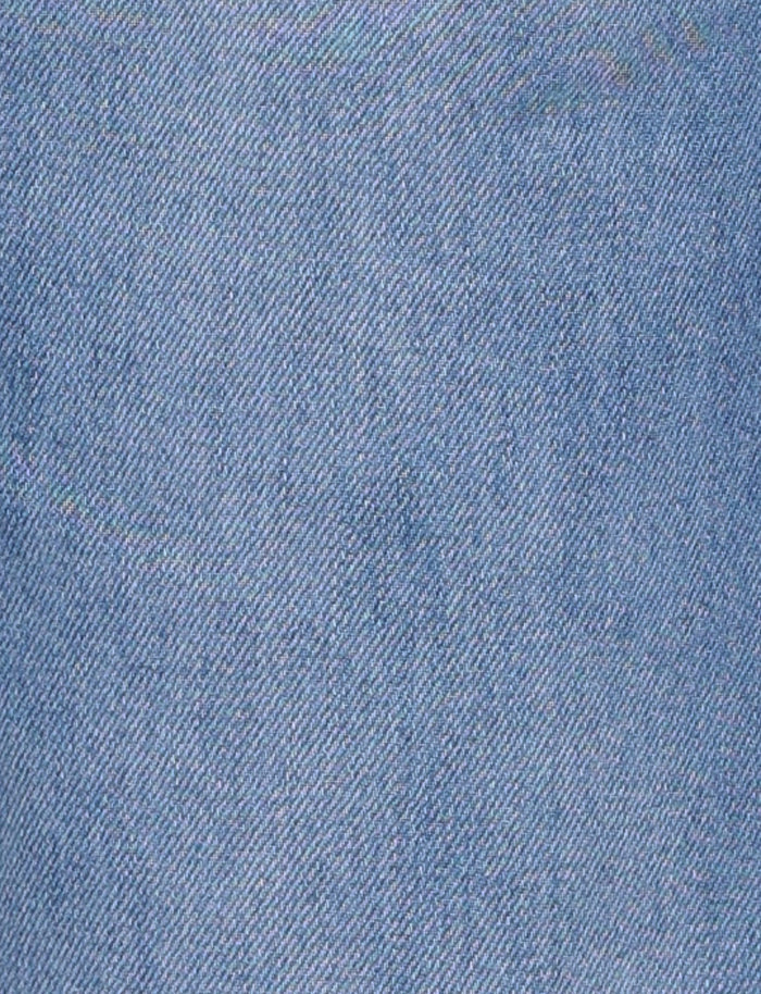 Close-up view of the AVEREE JEAN - BLUE : MID WASH from TIGERMIST, showcasing its light blue denim fabric with a diagonal weave pattern. The texture appears slightly worn, giving it a soft look, and the threads are tightly woven. There are no visible stains, rips, or marks on the fabric.