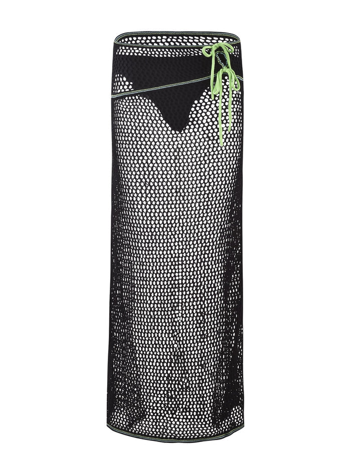 The AZARIA SKIRT - BLACK from TIGERMIST is a long black mesh skirt adorned with small white dots and an asymmetrical neon green lace-up detail on the upper right side. Its see-through material lends it a stylish and modern look.