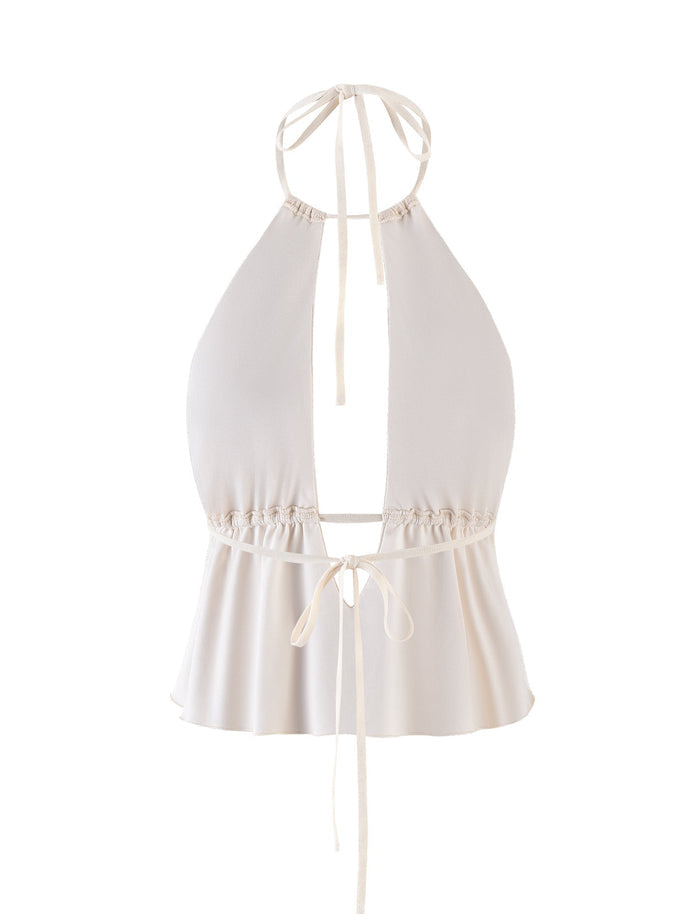 The BIRDEE TOP - WHITE : CREAM from TIGERMIST is a white halter-neck top featuring a deep V-neckline and an open back. It has a tie closure at the neck and an additional tie at the waist, which creates a ruched effect. The lower part is slightly flared, giving it a flowy appearance.