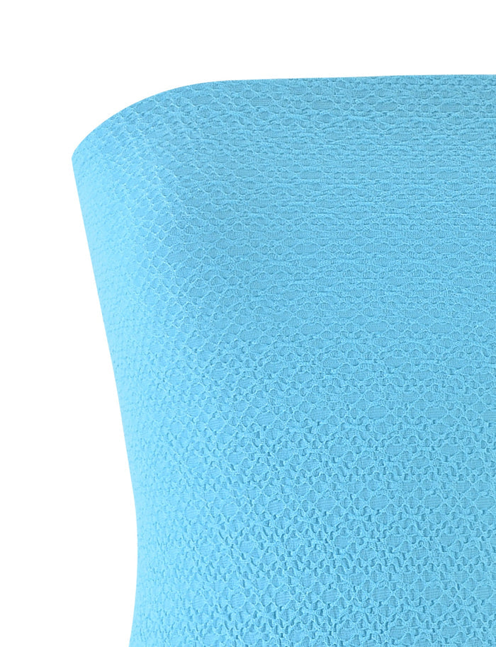 Close-up of the light blue, textured fabric from TIGERMIST's BOBBIE DRESS - BLUE, featuring a subtle pattern of small, diamond-shaped motifs. The angle accentuates its stretchability and softness, indicating it would be ideal for comfortable clothing or stylish upholstery.