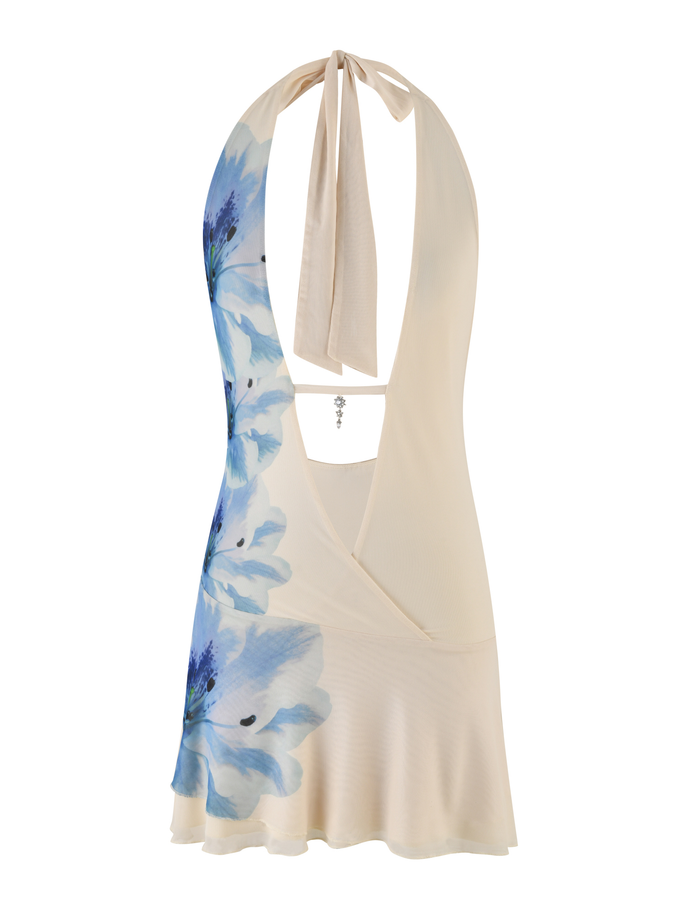 The BROOKS DRESS by TIGERMIST is a cream mini mesh dress with halter neck ties, open back, soft blue floral print on one side, and a ruffled hem for a flirty touch.