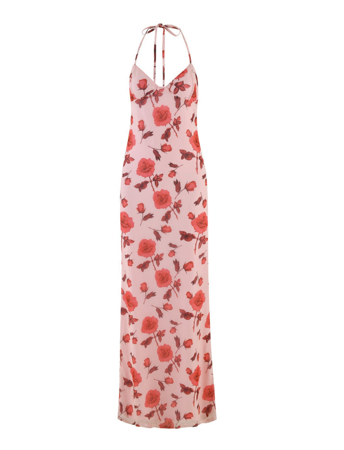 Introducing the BRYSTOL DRESS - RED : FLORAL by TIGERMIST, a sleeveless maxi dress featuring thin straps and a V-neckline. This elegant floor-length piece is adorned with a delicate floral pattern showcasing red roses on light pink fabric.