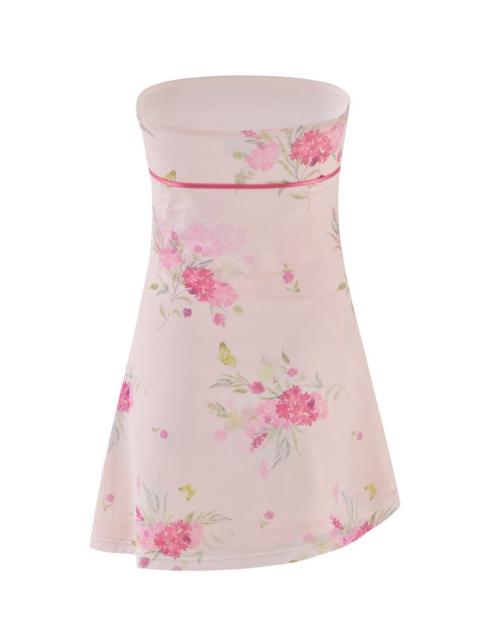 The CARSYN MINI DRESS by TIGERMIST boasts a strapless design with watercolor floral patterns of pink and green flowers on a light background, highlighting an A-line silhouette. It features a delicate pink trim along the top and an asymmetrical hemline for a contemporary flair.