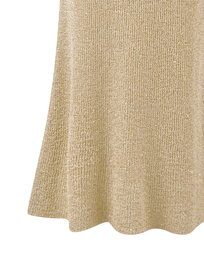 A close-up of the beige, textured fabric reveals its soft knit fabrication and a subtle pattern. The bottom edge curves slightly, hinting at its place in a garment similar to the CONNELL SKIRT - GOLD by TIGERMIST.