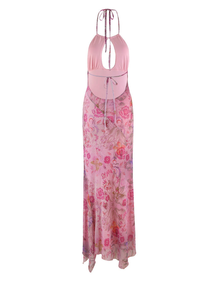 The TIGERMIST COSETTE DRESS - PINK : DELICATE FLORAL is a sleeveless dress featuring a multiwear halter neckline with a keyhole cutout. This elegant piece boasts a solid pink bodice and a floral-patterned skirt tied at the waist. The lightweight fabric gracefully flows down to the floor.