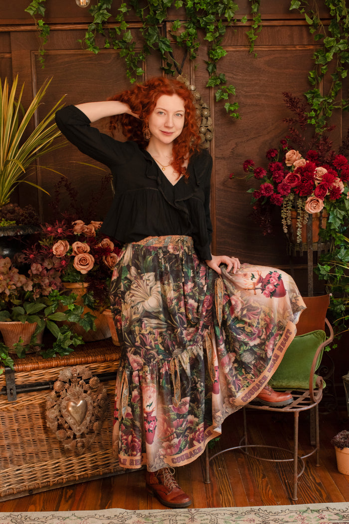 Model wearing a bamboo-viscose maxi-length skirt with Sacred Heart art and hidden affirmations — a soulful, wearable reminder to aim true and take heart - Market of Stars