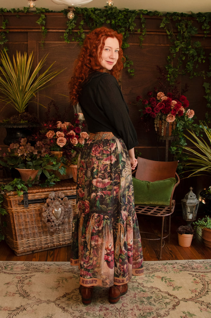 Model wearing a bamboo-viscose maxi-length skirt with Sacred Heart art and hidden affirmations — a soulful, wearable reminder to aim true and take heart - Market of Stars