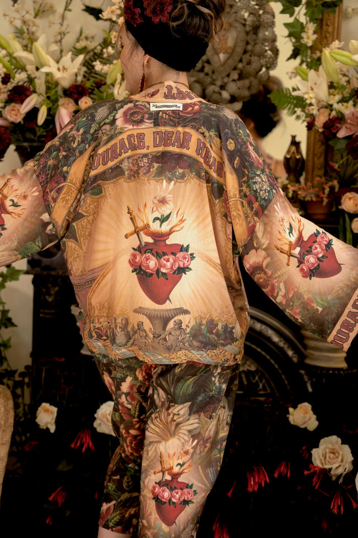 Model wearing Courage Dear Heart Pixie cut Duster featuring Victorian Sacred Heart art and hidden affirmations of courage and love on bamboo-based viscose – Market of Stars.
