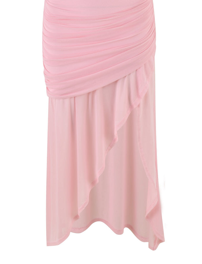 The COVE DRESS - PINK : BABY PINK by TIGERMIST is a feminine and elegant piece. It has a fitted silhouette with ruched detailing in the upper section, offering a flattering look. The lower part of the dress features an asymmetrical, flowing, and slightly sheer fabric with a ruffled hem that cascades to one side. The knee-length design in pastel pink adds to its charm.