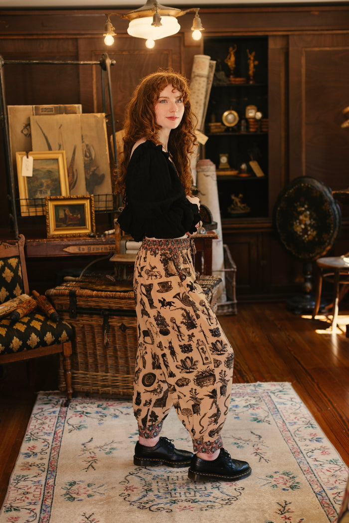 Model wearing relaxed viscose pant with elastic and drawstring waist, inspired by a mysterious Victorian scrapbook. This whimsical print celebrates the wonder hidden in ordinary things — Market of Stars.