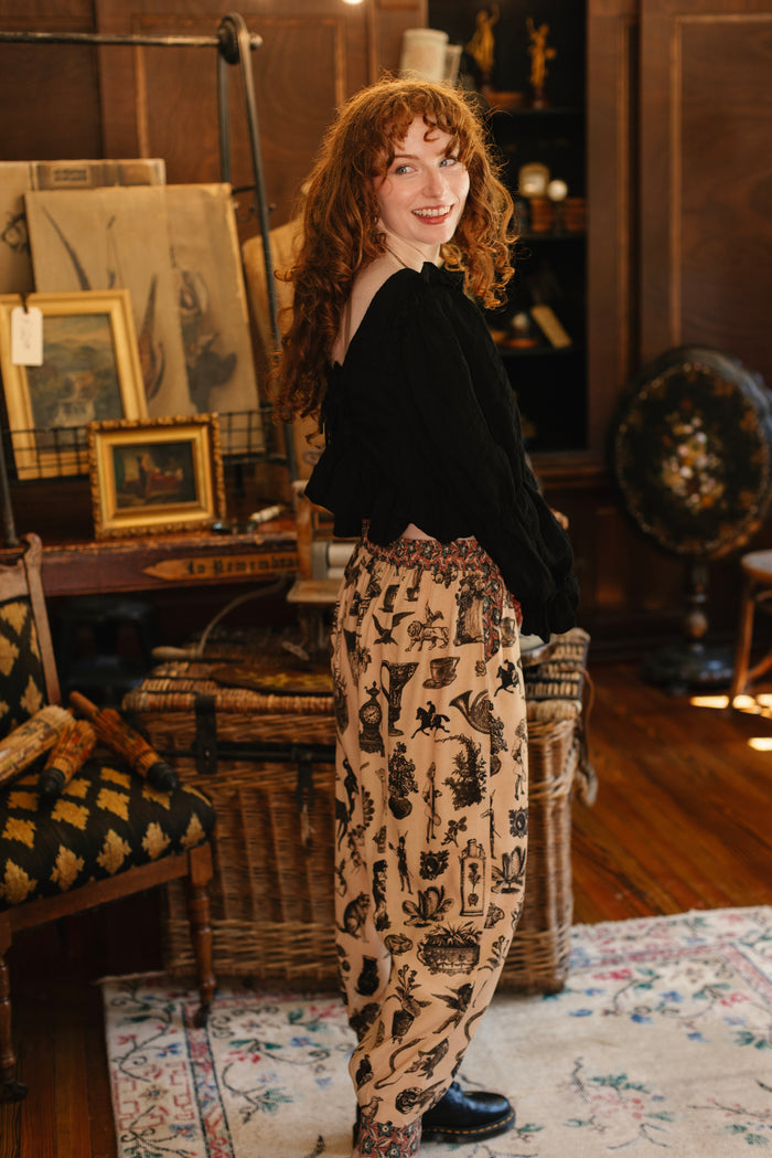 Model wearing relaxed viscose pant with elastic and drawstring waist, inspired by a mysterious Victorian scrapbook. This whimsical print celebrates the wonder hidden in ordinary things — Market of Stars.