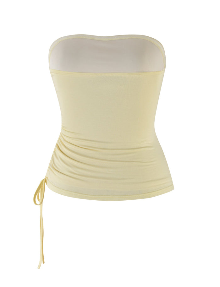 The DARIAN TOP - YELLOW : BUTTER by TIGERMIST is a strapless tube top with a ruched side tie detail. Crafted from high-stretch fabric, this form-fitting top features a smooth, simple design and embraces a bodycon silhouette.