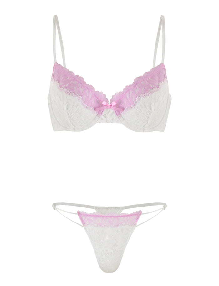 The DEVYN SET - MULTI : WHITE/ PINK by TIGERMIST features a white lace bra with light pink detailing on the upper cups and a small pink bow in the center, paired with matching white lace bottoms that have light pink detailing on the waistband and semi-sheer sides. The bra includes adjustable shoulder straps for a perfect fit.