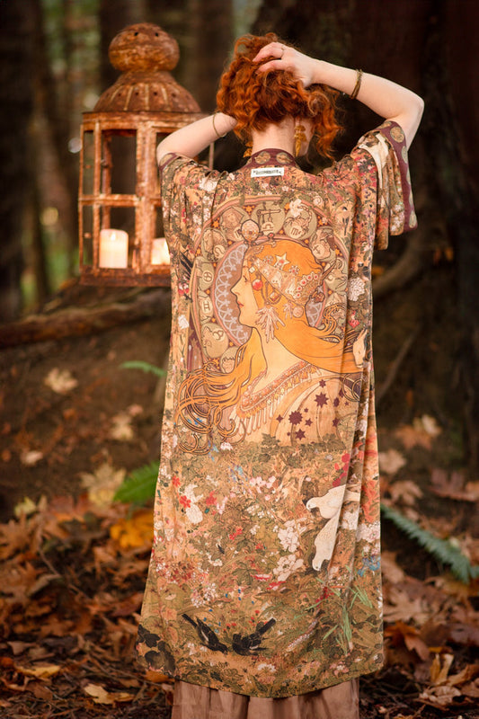 Model wearing Dreamweaver Opera Duster – featuring Alphonse Mucha’s zodiac woman, celestial crown, and burgundy zodiac trim inspired by 1970s luxe bohemian style – Market of Stars.