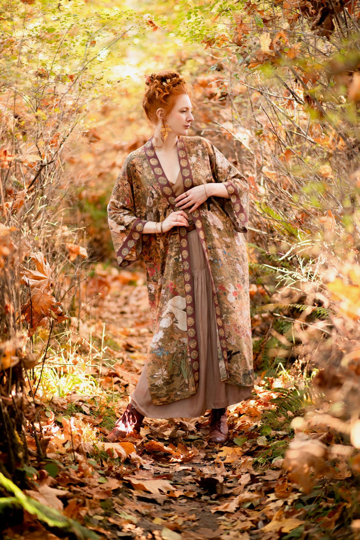 Model wearing Dreamweaver Opera Duster – featuring Alphonse Mucha’s zodiac woman, celestial crown, and burgundy zodiac trim inspired by 1970s luxe bohemian style – Market of Stars.