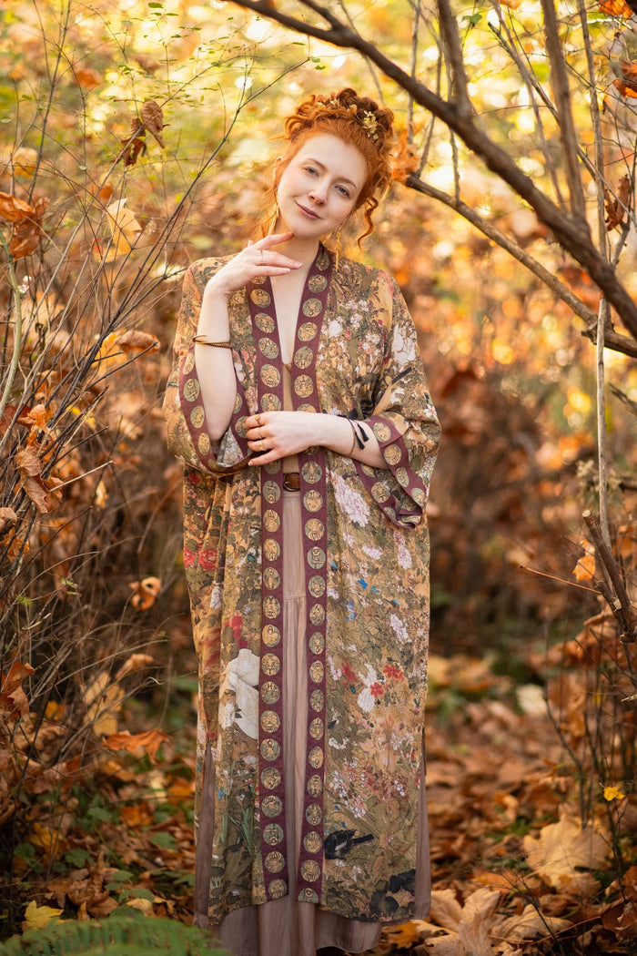 Model wearing Dreamweaver Opera Duster – featuring Alphonse Mucha’s zodiac woman, celestial crown, and burgundy zodiac trim inspired by 1970s luxe bohemian style – Market of Stars.