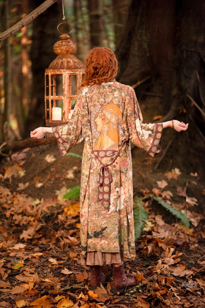 Model wearing Dreamweaver Opera Duster – featuring Alphonse Mucha’s zodiac woman, celestial crown, and burgundy zodiac trim inspired by 1970s luxe bohemian style – Market of Stars.