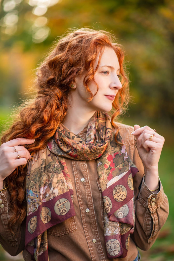 Model wearing Dreamweaver Zodiac Scarf – featuring Alphonse Mucha’s 1896 celestial woman surrounded by zodiac signs and floral scroll artwork – Market of Stars.