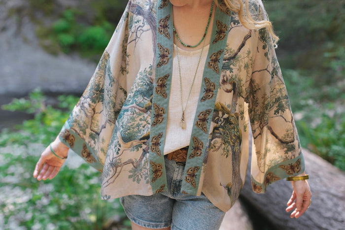 Model wearing Earth and Sky Pixie Duster featuring Charles Aston’s tree art and antique moth illustrations – a soft, nature-inspired layering piece – Market of Stars.