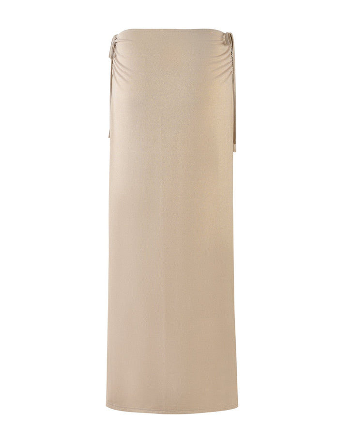 A gold, floor-length skirt from TIGERMIST with a subtle sheen. The ELLIANA SKIRT features simple side drawstrings near the top for a slightly gathered effect and a sleek, minimalist silhouette.