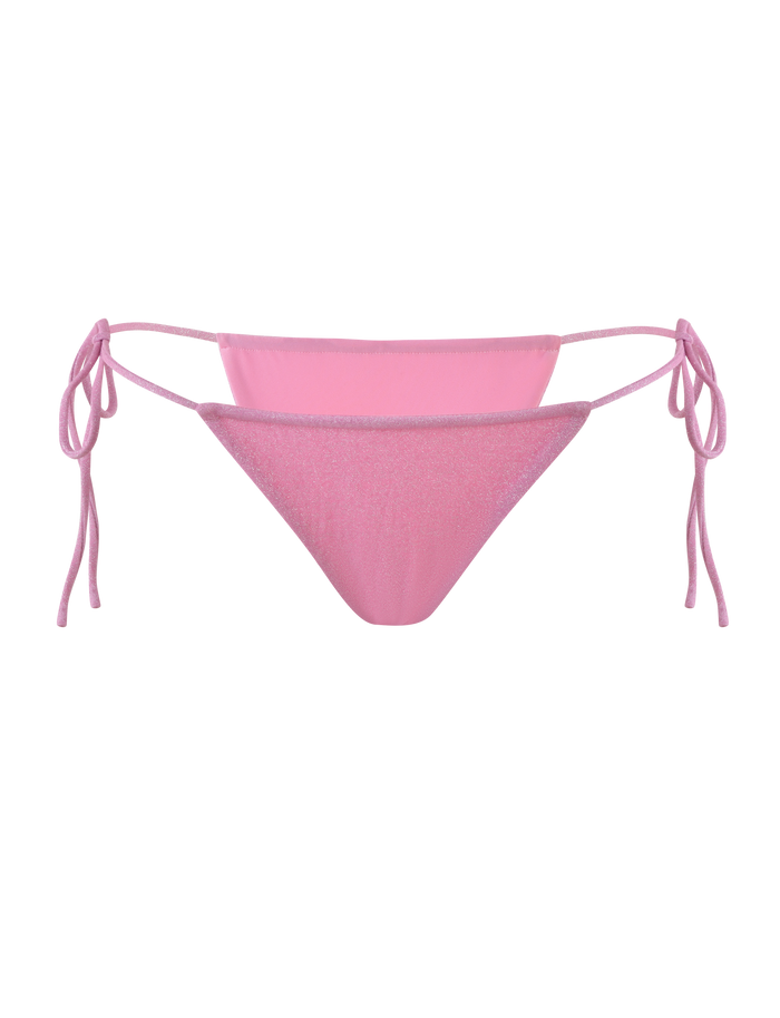 The TIGERMIST ELLISON BIKINI BOTTOM in baby pink features luxe shimmer lurex fabric, adjustable side ties, and a cheeky cut, shown on a plain light pink background.