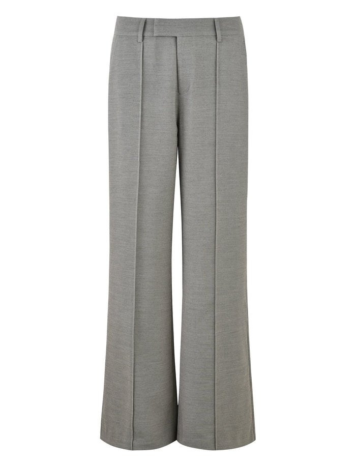 The EMALINE PANT in grey from TIGERMIST is displayed. These high-waisted trousers boast a tailored fit with front pleats and belt loops at the waistband, offering a polished look.
