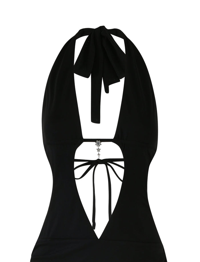 A sleek black halter neck top with an open back and a deep V neckline, reminiscent of the ESHA MAXI DRESS - BLACK by TIGERMIST. The neckline features a decorative silver charm in the center, connected to thin black straps that tie at the back. The fabric appears smooth and fitted, completing this bodycon silhouette.